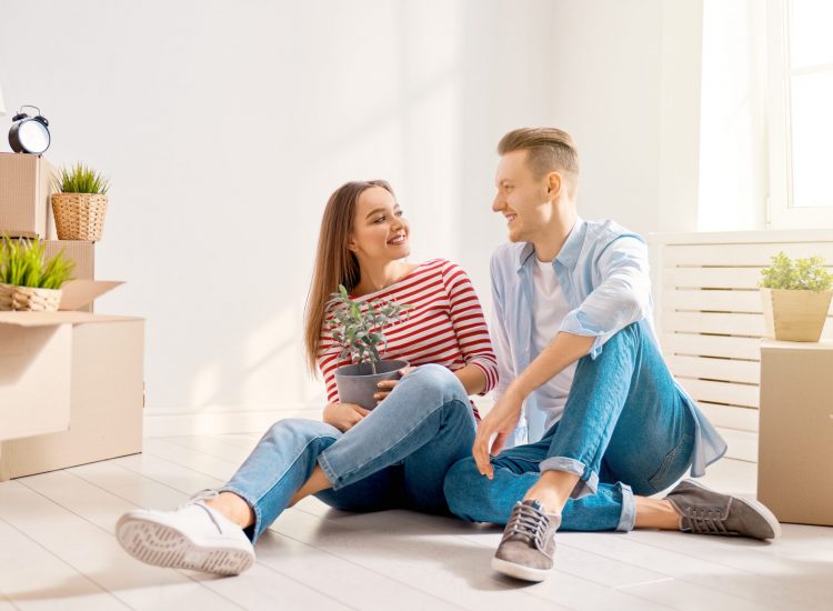 land development couple moving into a new home sitting on living room floor
