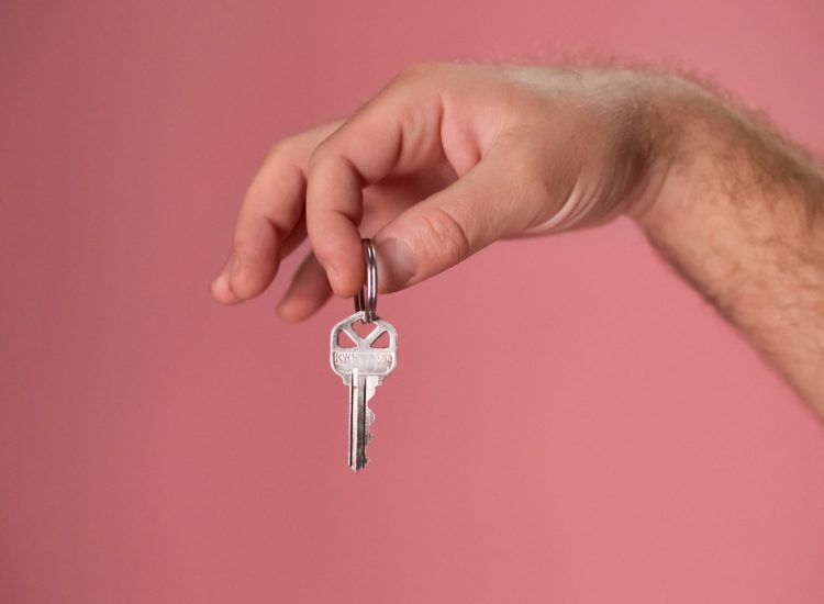 Tannum Sands Real Estate - person holding key with pink background